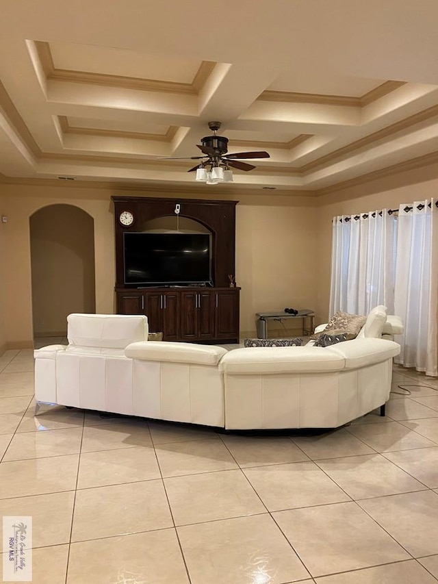 tiled living room with coffered ceiling, ceiling fan, and ornamental molding