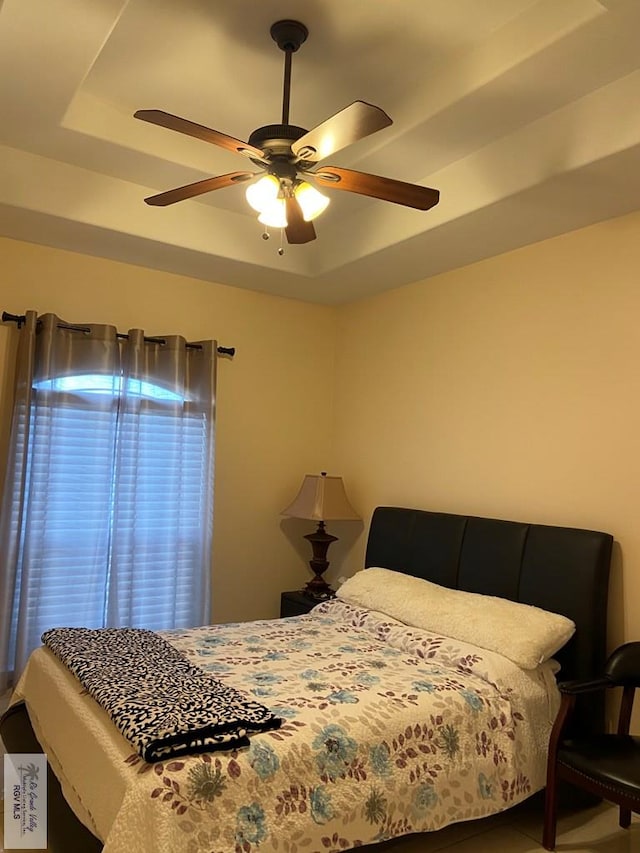 bedroom with a tray ceiling and ceiling fan