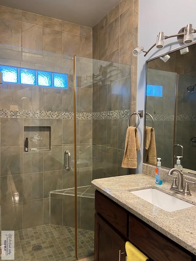 bathroom featuring vanity and a shower with door