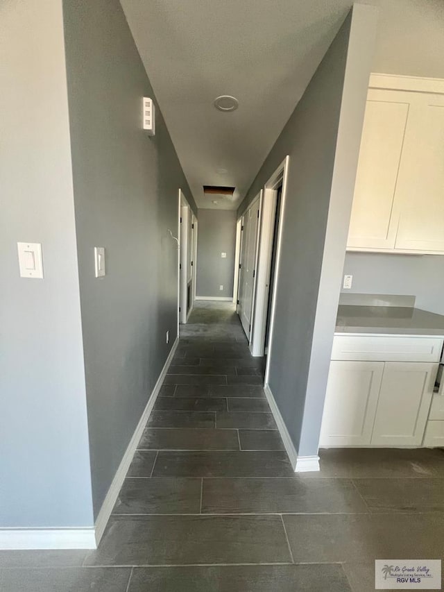 hallway featuring baseboards and wood tiled floor