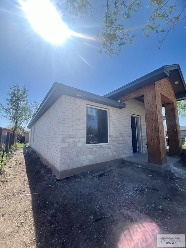 view of side of home with brick siding