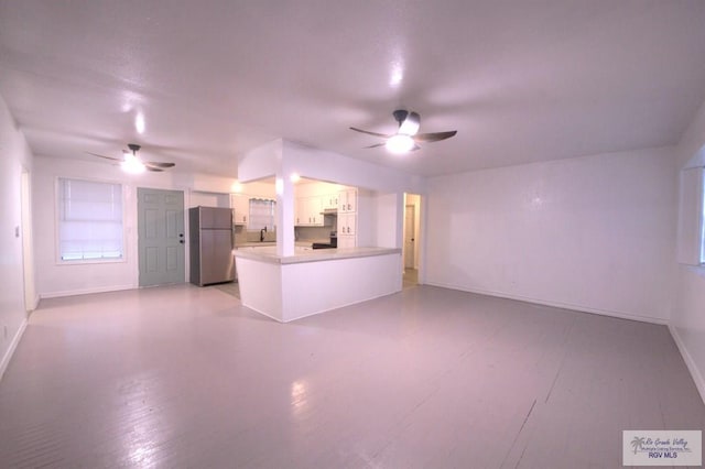 unfurnished living room featuring ceiling fan