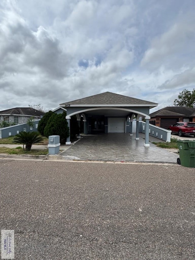 view of front of house with a garage and a shingled roof