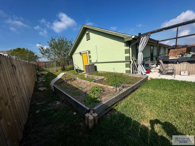 view of property exterior with a patio, cooling unit, and a lawn