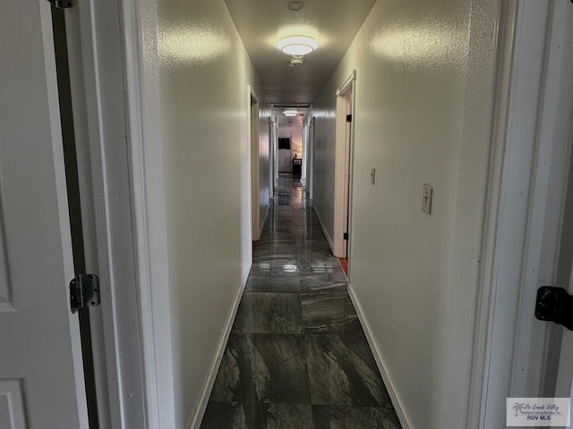 hallway with dark tile patterned floors