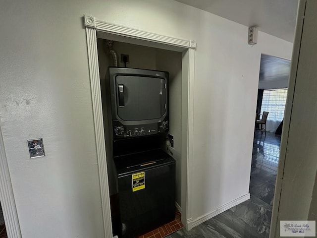 utility room featuring stacked washer / dryer