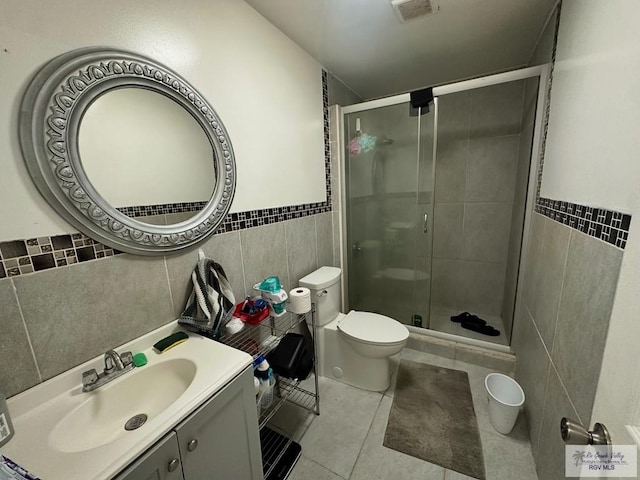 bathroom with tile patterned floors, an enclosed shower, and tile walls