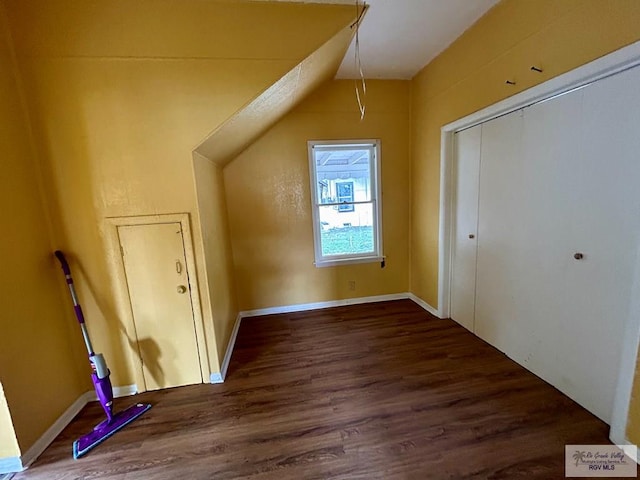 bonus room with dark wood-style flooring, baseboards, and vaulted ceiling
