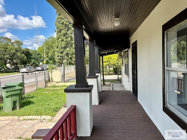 wooden deck featuring a lawn and fence
