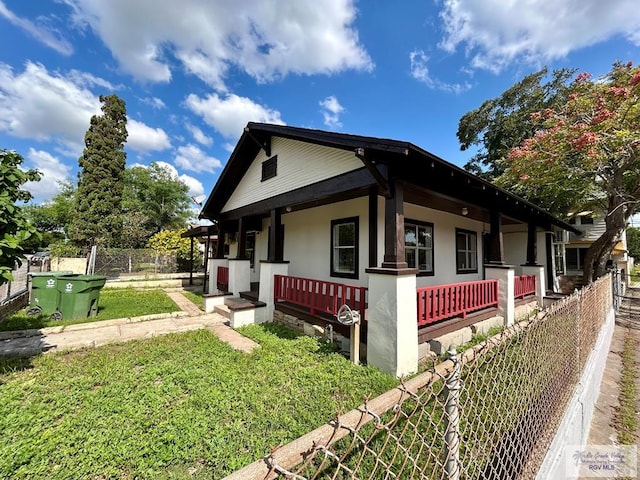 view of side of home with covered porch and fence