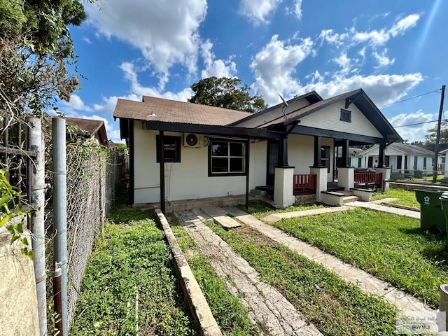 bungalow-style home featuring fence, a front lawn, and a porch