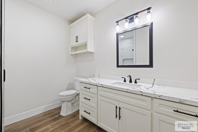 25219 Chelsea Ln, Harlingen, TX 78552 - full bath with vanity, wood finished floors, baseboards, and toilet