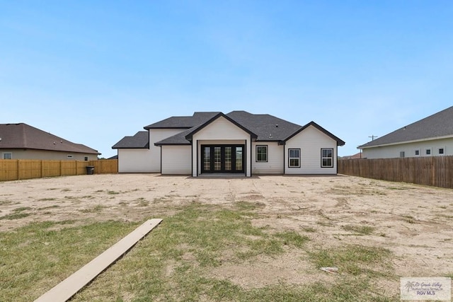 25219 Chelsea Ln, Harlingen, TX 78552 - rear view of house with french doors and a fenced backyard