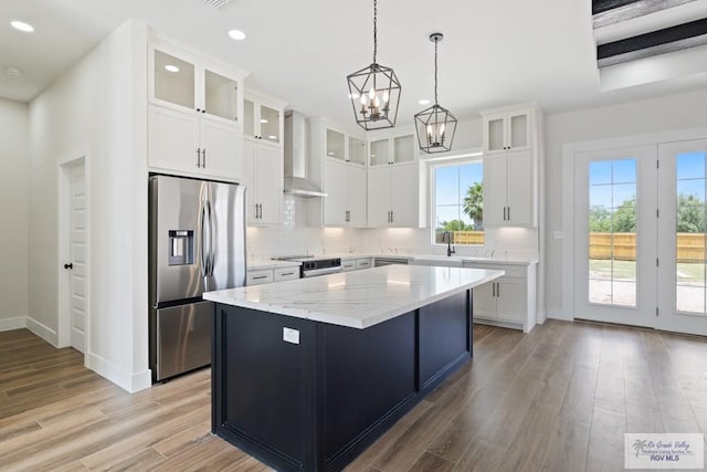 25219 Chelsea Ln, Harlingen, TX 78552 - kitchen with stainless steel appliances, wall chimney range hood, a chandelier, recessed lighting, and light wood-style flooring