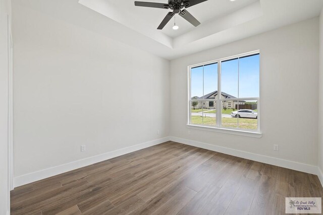 25219 Chelsea Ln, Harlingen, TX 78552 - spare room with a raised ceiling, baseboards, wood finished floors, and a ceiling fan