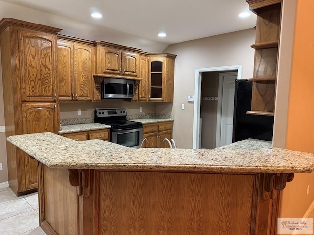 kitchen featuring stainless steel appliances, light stone countertops, light tile patterned floors, and kitchen peninsula