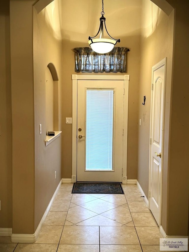 doorway to outside featuring a towering ceiling and light tile patterned flooring