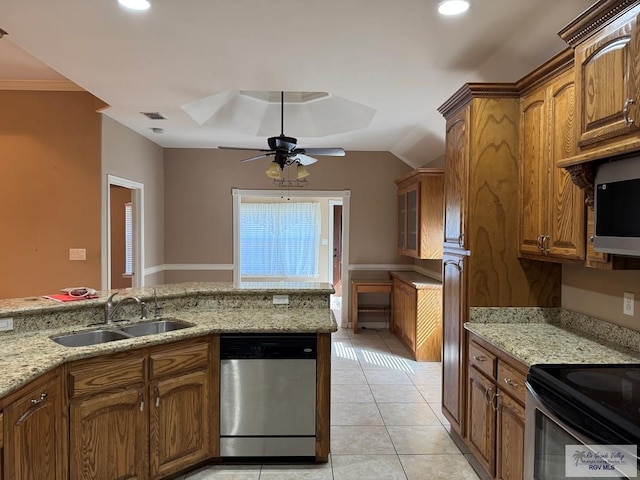 kitchen with sink, light tile patterned floors, light stone countertops, and appliances with stainless steel finishes