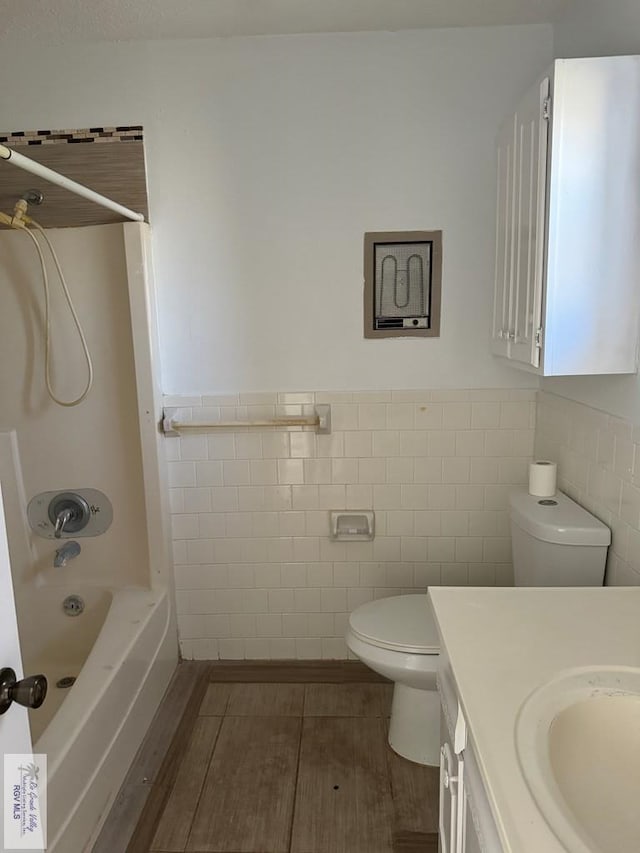 full bathroom with vanity, shower / bath combination, toilet, and tile walls