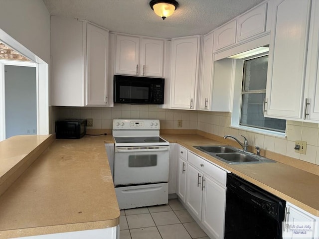 kitchen with tasteful backsplash, sink, black appliances, light tile patterned floors, and white cabinetry