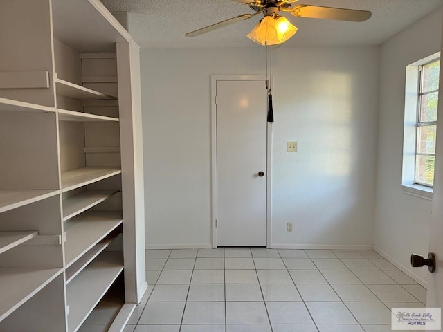 tiled entrance foyer featuring ceiling fan, plenty of natural light, and a textured ceiling