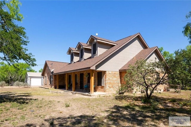 back of house featuring a garage and an outbuilding