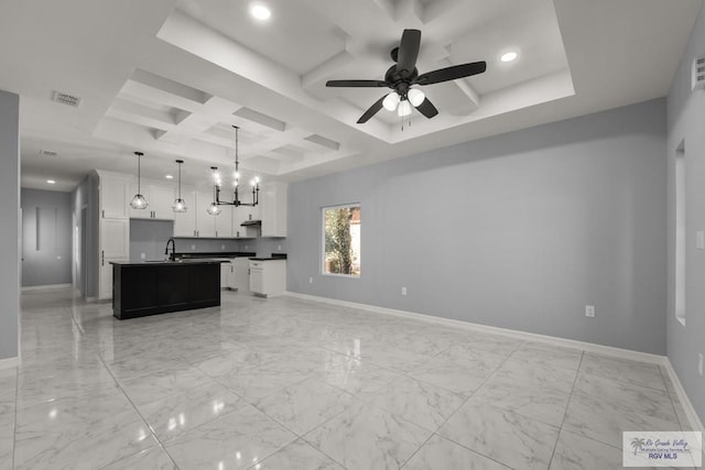 kitchen with coffered ceiling, baseboards, open floor plan, marble finish floor, and dark countertops