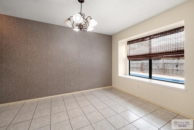 5 Mantua St, Brownsville, TX 78526 - empty room with a chandelier, a textured ceiling, and light tile patterned floors