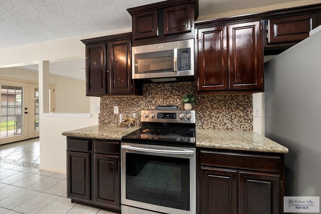 5 Mantua St, Brownsville, TX 78526 - kitchen featuring appliances with stainless steel finishes, backsplash, light tile patterned floors, dark brown cabinets, and light stone countertops