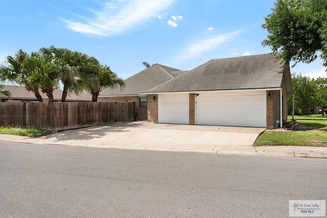 5 Mantua St, Brownsville, TX 78526 - view of front of property with a garage, concrete driveway, and brick siding