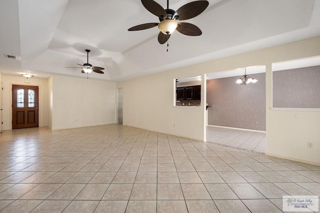 5 Mantua St, Brownsville, TX 78526 - empty room featuring a raised ceiling, a ceiling fan, light tile patterned floors, and a chandelier