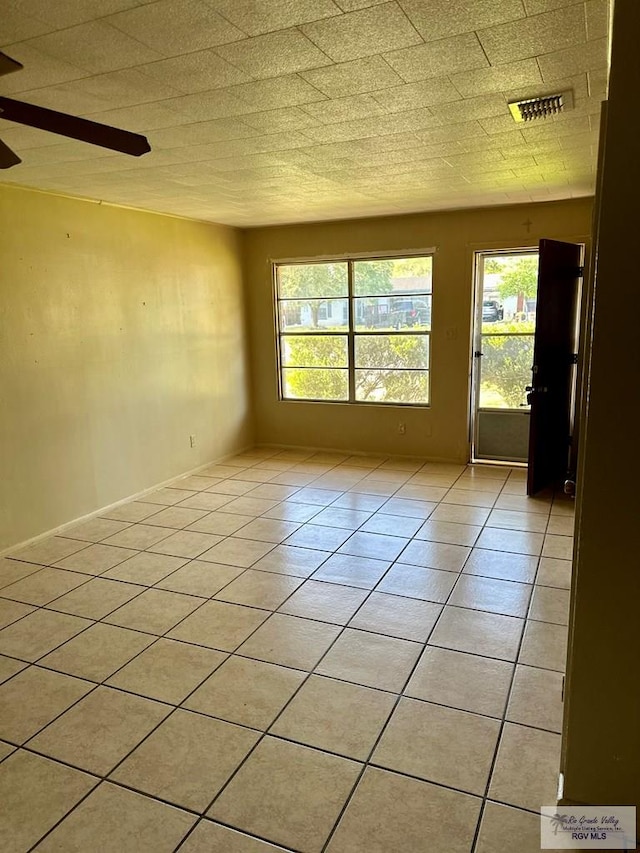 697 W White Ave, Raymondville, TX 78580 - spare room with visible vents, light tile patterned floors, ceiling fan, and plenty of natural light
