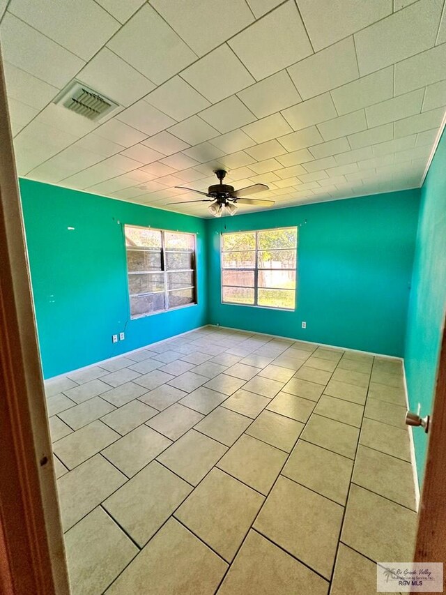 697 W White Ave, Raymondville, TX 78580 - empty room featuring light tile patterned flooring, baseboards, a ceiling fan, and visible vents
