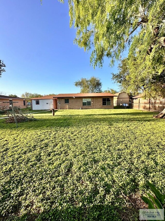 697 W White Ave, Raymondville, TX 78580 - back of property with fence and a lawn