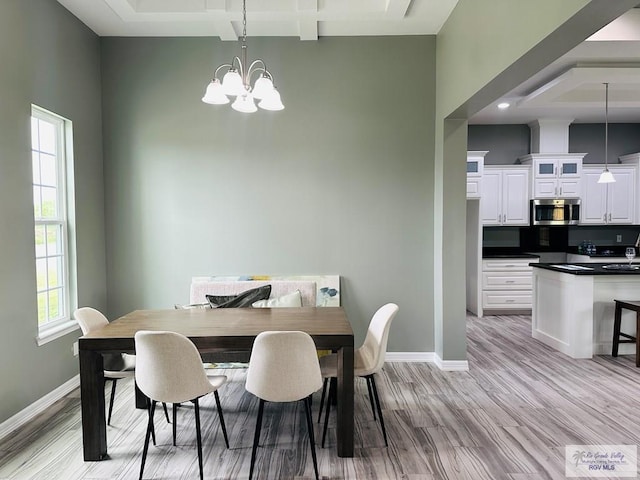 dining area featuring a wealth of natural light, light hardwood / wood-style floors, and an inviting chandelier