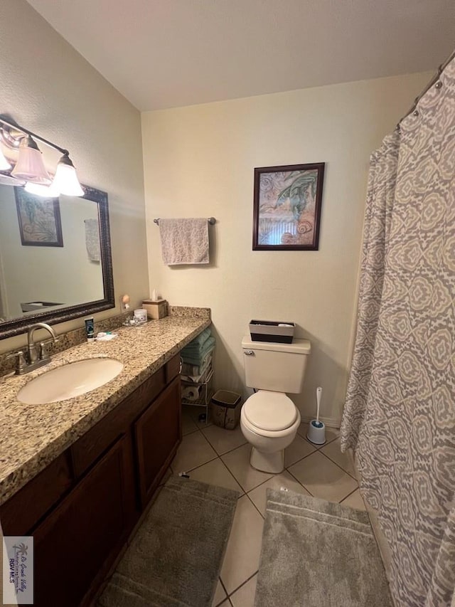 bathroom with tile patterned flooring, vanity, and toilet