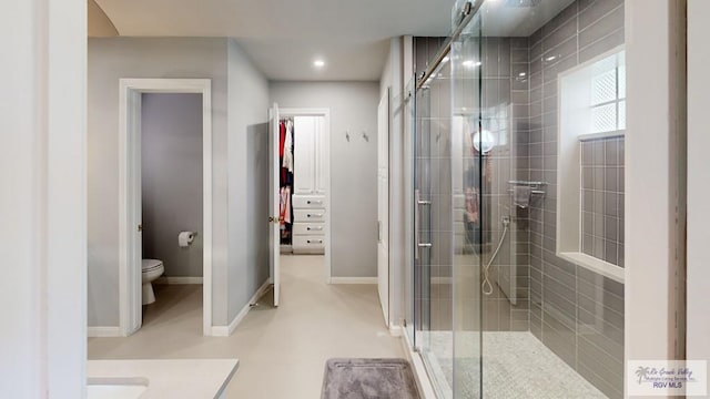 bathroom featuring vanity, toilet, and a shower with door