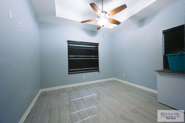 spare room with baseboards, wood finished floors, and ceiling fan