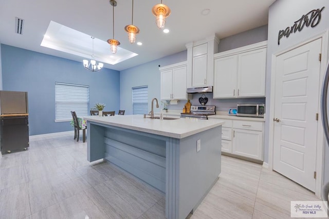 3585 Westcreek Dr, Brownsville, TX 78526 - kitchen with stainless steel appliances, under cabinet range hood, a chandelier, white cabinetry, and light countertops