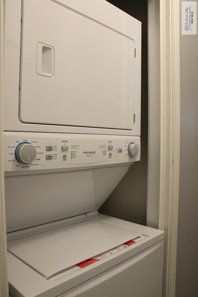 clothes washing area featuring mail boxes and stacked washer / drying machine