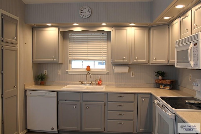 kitchen with white appliances, sink, and gray cabinets
