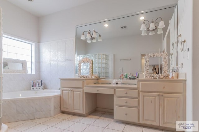 bathroom with tile patterned flooring, vanity, tile walls, and tiled tub