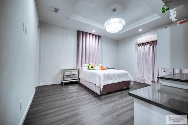 bedroom featuring dark hardwood / wood-style floors and a raised ceiling