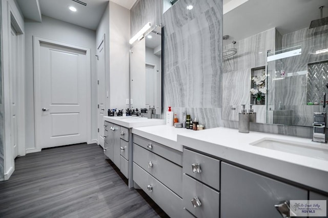 bathroom featuring vanity, a shower with shower door, and wood-type flooring