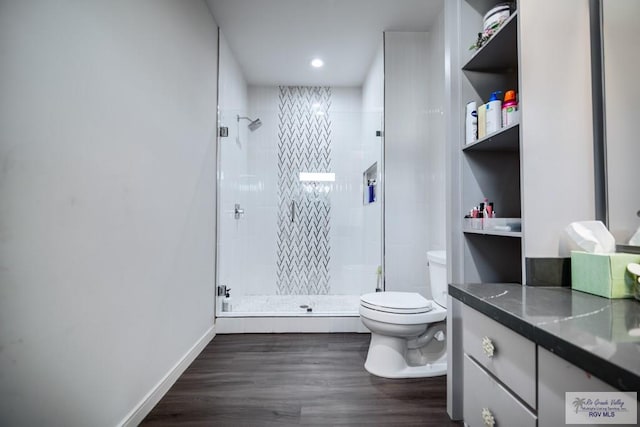 bathroom featuring hardwood / wood-style floors, vanity, toilet, and walk in shower