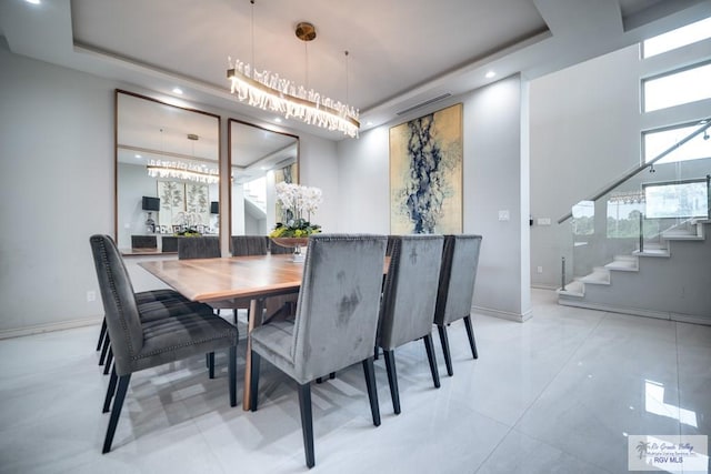 tiled dining room featuring a raised ceiling