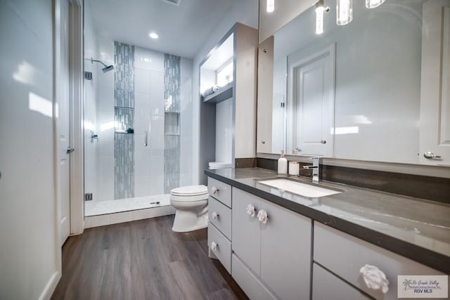 bathroom with hardwood / wood-style floors, vanity, toilet, and an enclosed shower