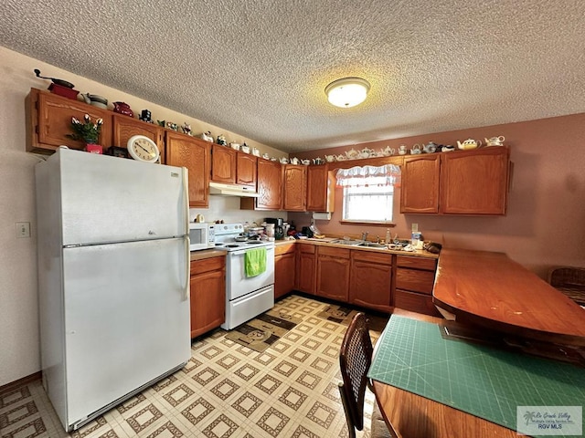 kitchen featuring a textured ceiling, sink, and white appliances