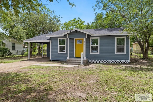 1522 Ball St, Harlingen, TX 78550 - view of front facade featuring dirt driveway, roof with shingles, and a carport