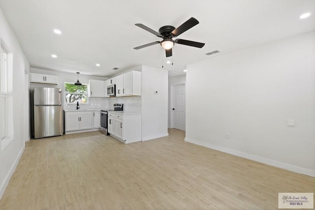 1522 Ball St, Harlingen, TX 78550 - kitchen featuring appliances with stainless steel finishes, ceiling fan, white cabinets, light countertops, and recessed lighting